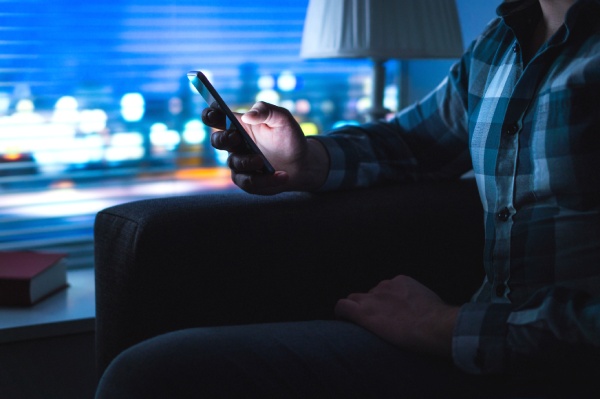 Man using mobile phone at home late at night
