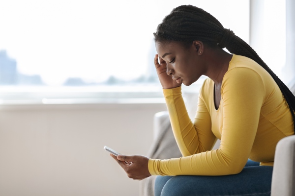 Upset woman looking at cellphone screen