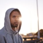 young sportsman wearing a hoodie and looking away