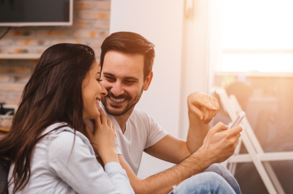 couple is sitting on the floor and looking at each other