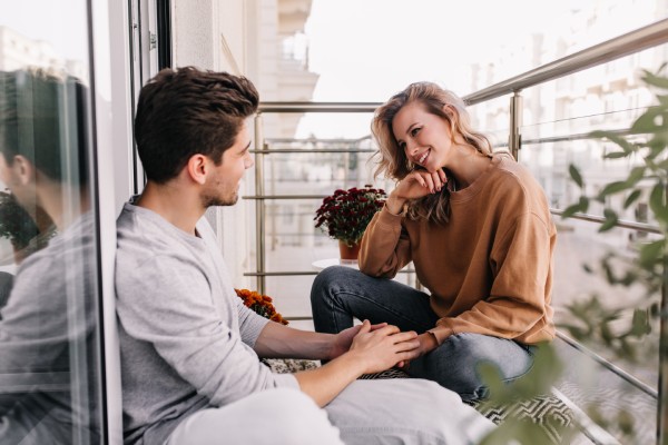young lady sitting on the balcony with a guy