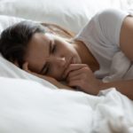 woman lying on her side at bed